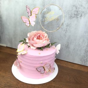 fake food:  pink fake birthday cake decorated with pink butterflies and large rose on top.